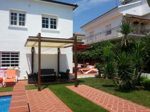 a backyard with a patio umbrella and a pool at Villa Habana in El Vendrell