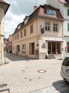 a building on a street with a car parked in front at Hotel - Weinbar FAHR AWAY in Volkach