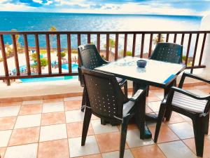 a table and chairs on a balcony with the ocean at Rocas del Mar in Costa Del Silencio