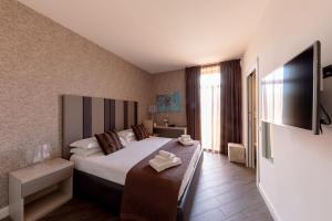 a hotel room with a bed and a flat screen tv at Blue Inn Luxury Suites in Rome
