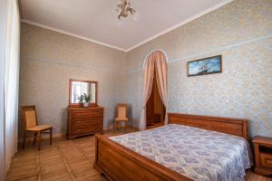 een slaapkamer met een bed, een dressoir en een spiegel bij Ligo Morskaya in Simeiz