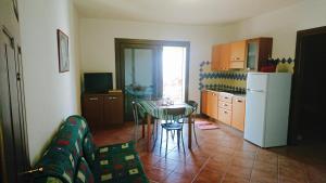 a kitchen with a couch and a table and a refrigerator at Borgo Bellavista Badesi in Badesi