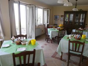 パオラにあるB&B L'Eucaliptoのダイニングルーム(緑のテーブルクロス付きテーブル2台付)