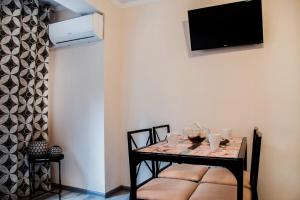 ein Esszimmer mit einem Tisch und einem TV an der Wand in der Unterkunft Apartments Relax in Valencia