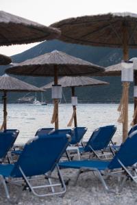 a group of blue chairs and umbrellas on a beach at Akroyiali Resort in Vasiliki