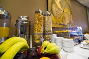 a table with fruit and other food items on it at Flisvos Hotel Nafpaktos in Nafpaktos