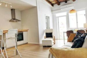 Una sala de estar con un sofá, una mesa y sillas. en Casita de pescador III, en Calafell