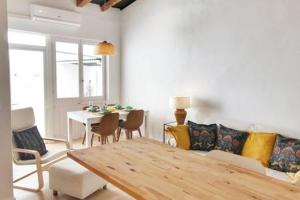 Una sala de estar con un sofá, una mesa y sillas. en Casita de pescador III, en Calafell