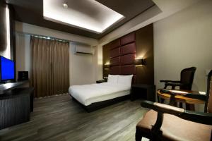 een hotelkamer met een bed en een televisie bij Two Fukun Hotel in Jiaoxi