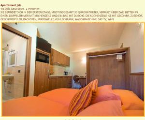 uma fotografia de um quarto com uma cama laranja em Appartamento Jek em Livigno