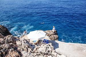 a group of people swimming in the ocean on the rocks at Sunset Villa Hotel in Kaş