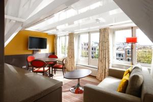 a living room with a couch and a table at Krasnapolsky Apartments in Amsterdam