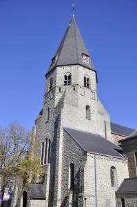 a church with a tower with a clock on it at Hotel Brasserie De Beiaard in Torhout