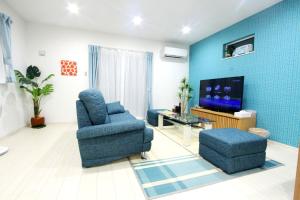 un soggiorno con sedia e TV di Premium Cottage Comfort Okinawa a Onna