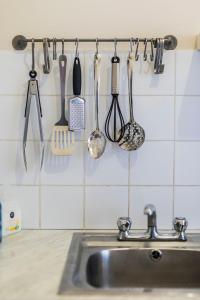 a kitchen sink with utensils hanging on a wall at St Patricks Cathedral Self Catering in Dublin