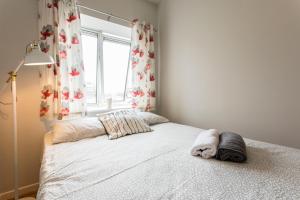 a bedroom with a white bed and a window at St Patricks Cathedral Self Catering in Dublin