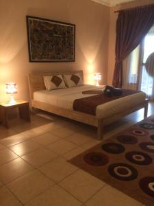Un pat sau paturi într-o cameră la Ada Waktu Homestay