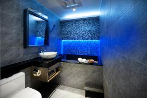 bagno blu con lavandino e servizi igienici di Two Fukun Hotel a Jiaoxi