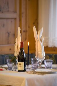 una botella de vino sentada en una mesa con copas de vino en Hotel Panorama en Molveno