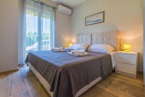 a bedroom with a large bed with two towels on it at Apartmani Vesna in Opric +87 photos