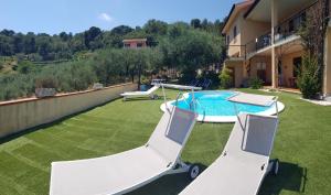 a backyard with a pool and two lawn chairs at Tenuta Domine in Imperia