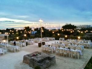 un ampio gruppo di tavoli e sedie con luci di Casale del Murgese Country Resort a Savelletri