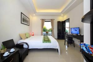 a bedroom with a large white bed and a desk at Hoi An Green View Homestay & Villa in Hoi An