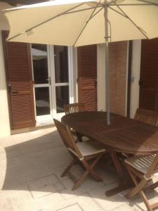 a wooden table and chairs with an umbrella at Casa Vacanze Carlappiano in Piombino