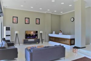a lobby with a reception desk with a tv in it at Legend Business Hotel Batumi in Batumi +26 photos