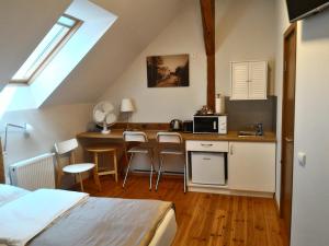um quarto com uma cama e uma cozinha com um micro-ondas em Miško Apartments em Silutė