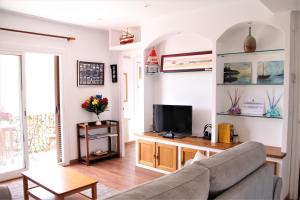 a living room with a couch and a tv at Apartamento con Licencia en Sitges in Sitges