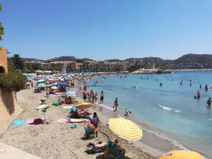 a crowd of people on a beach with umbrellas at casa DOBRADA in Benissa