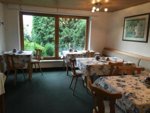 a dining room with tables and a large window at Pension Anna in Löbau