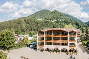a hotel with a mountain in the background at Wirtshaushotel Alpenrose in San Lorenzo di Sebato