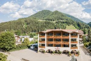 サン・ロレンツォ・ディ・セバートにあるWirtshaushotel Alpenroseの山を背景にしたホテル