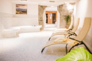 a row of chairs in a room with a bath tub at Wirtshaushotel Alpenrose in San Lorenzo di Sebato +62 photos