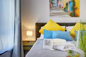 a bed with blue and yellow pillows and a sign on it at D&A Amphitheatre Apartments with free parking in Pula