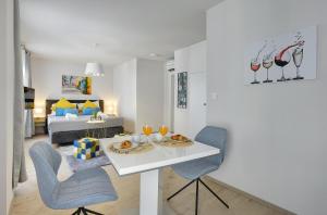 a living room with a table and chairs and a bed at D&A Amphitheatre Apartments with free parking in Pula
