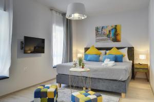 a bedroom with a bed with blue and yellow pillows at D&A Amphitheatre Apartments with free parking in Pula