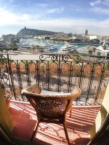 a balcony with a chair and a view of a harbor at Barceloneta Port Ramblas in Barcelona