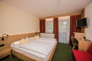 een hotelkamer met een bed en een televisie bij Wirtshaushotel Alpenrose in San Lorenzo di Sebato