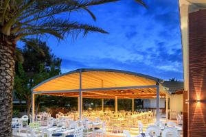a group of tables and chairs under a pavilion at Alexandra Beach Spa Resort in Potos
