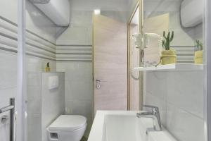 a white bathroom with a toilet and a sink at D&A Amphitheatre Apartments with free parking in Pula
