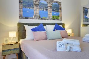 a bedroom with a bed with a painting on the wall at D&A Amphitheatre Apartments with free parking in Pula