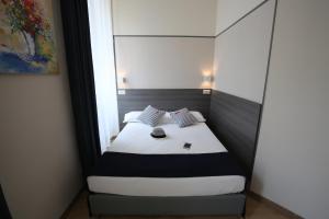 a bed room with a white bed and a white bedspread at Boutique Hôtel Neptune Nice in Nice