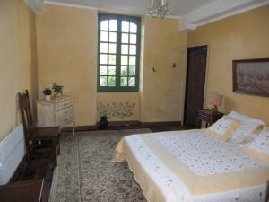 a bedroom with a bed and a dresser and a window at Chambres d'Hôtes Aroha in Sorde-lʼAbbaye