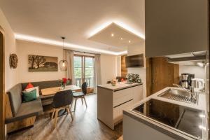 a kitchen and living room with a table and a dining room at Haus Oswald in Ellmau