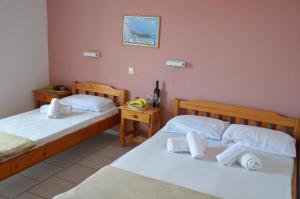 two beds in a room with two tables at Asteri's Summer in Paralia Katerinis