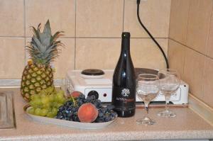 a bottle of wine next to a bowl of fruit and wine glasses at Asteri's Summer in Paralia Katerinis
