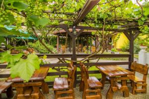 een houten tafel en stoelen onder een pergola bij Penzion Anareta in Frýdek-Místek